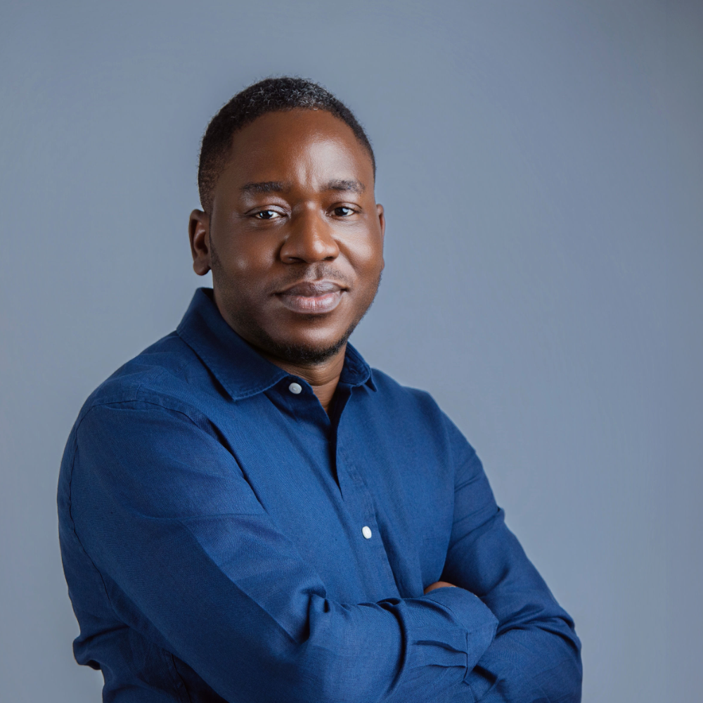 Tunde Adeniran, Product Manager at Meta, in a navy shirt with arms crossed